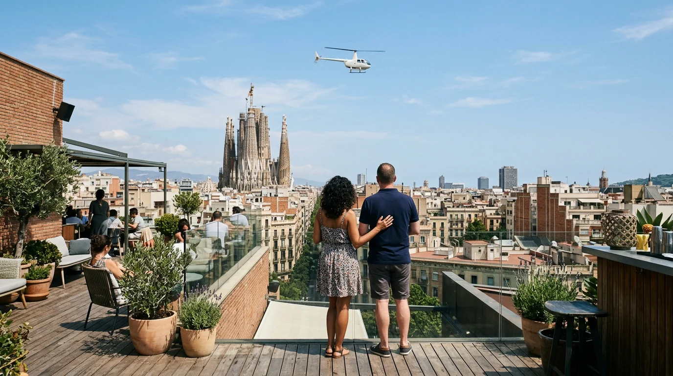 A couple on a Barcelona rooftop terrace watch a white helicopter pass over the Eixample, the Sagrada Familia beyond