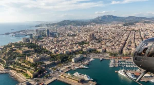 Aerial view of the Barcelona coastline and city skyline seen from a helicopter cockpit on a clear day.