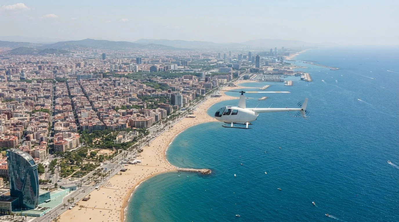 Small white helicopter flying over Barceloneta beach and the Barcelona waterfront, the coast stretching north to the horizon